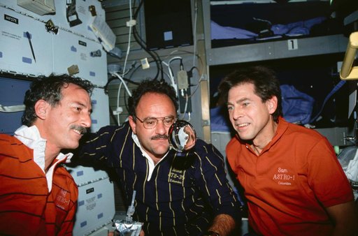 STS-35 crewmembers watch a sphere of water float on OV-102's middeck