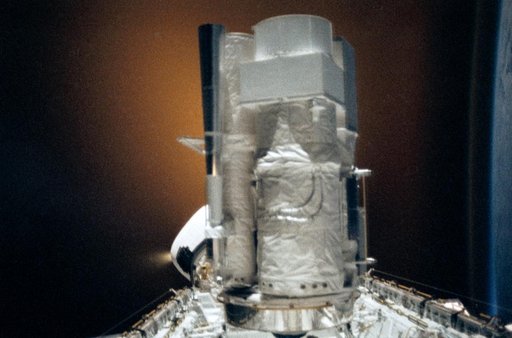 STS-35 ASTRO-1 in OV-102's payload bay silhouetted against RCS firing