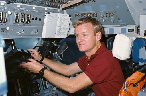 STS-36 Pilot Casper reaches for laptop computer on OV-104's flight deck