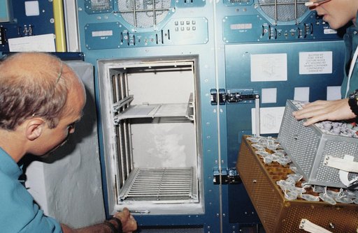 STS-40 crewmembers remove specimens from SLS-1 Rack 9 Refrigerator / Freezer
