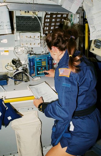STS-40 MS Jernigan works at SLS-1 Rack 1 workstation with intravenous system