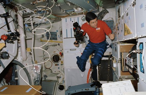 STS-41 Pilot Cabana holds 16mm camera on OV-103's middeck