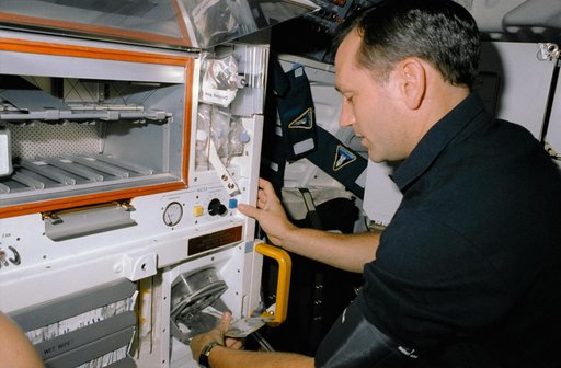 STS-41 MS Akers rehydrates a grapefruit drink at OV-103's middeck galley