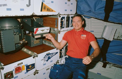 STS-41 MS Melnick displays US Coast Guard decal on OV-103's middeck