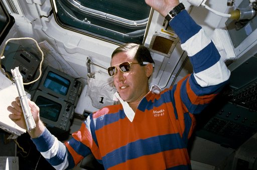 STS-43 Pilot Baker reviews checklist on OV-104's aft flight deck