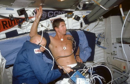 STS-44 MS Musgrave assists Pilot Henricks with DSO 478 LBNP device on middeck