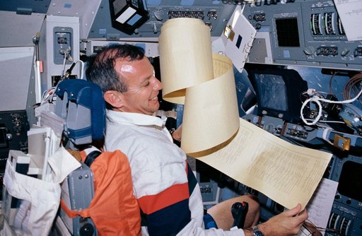 STS-45 Pilot Duffy wrestles with a TAGS printout on OV-104's flight deck