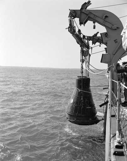 Mercury capsule mock-up suspended from ship during water egress training
