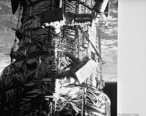 Astronauts Thornton & Akers on HST photographed by Electronic Still Camera