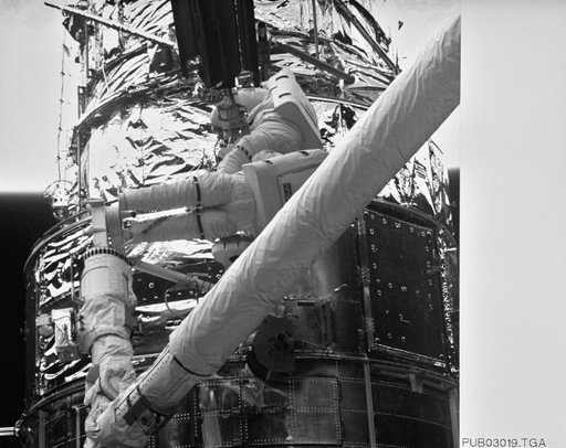 Astronauts Thornton & Akers on HST photographed by Electronic Still Camera