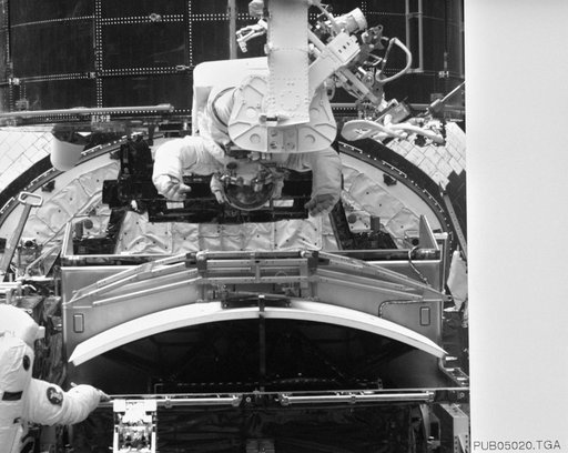 Astronaut Jeffrey Hoffman on RMS robot arm during HST repairs