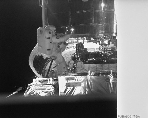 Astronaut Jeffrey Hoffman on RMS robot arm during HST repairs
