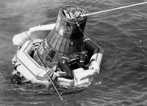 Navy frogman astride Sigma 7 floatation collar to secure tow line