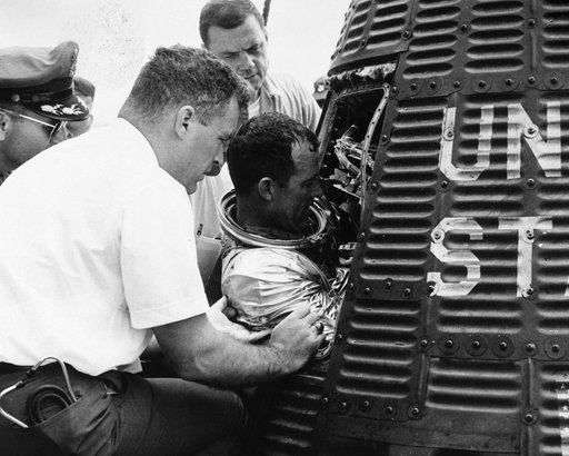 Astronaut Gordon Cooper is assisted backing out of his spacecraft "Faith 7"