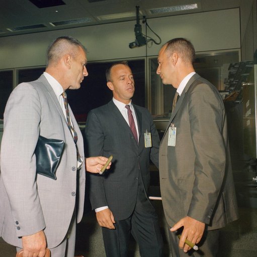 Three MSC officials hold discussion in Mission Control room during Gemini 11
