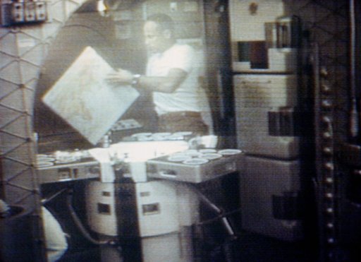 Astronaut Jack Lousma looks at map of Earth in ward room of Skylab cluster