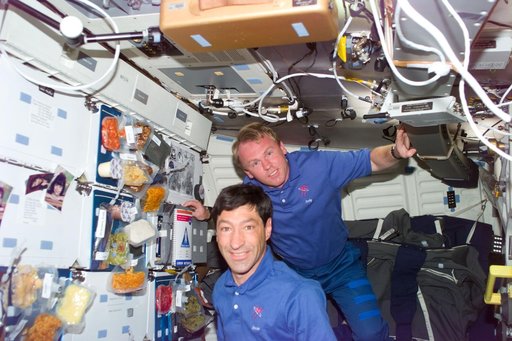 Runco and Thomas show off trays of food on the middeck