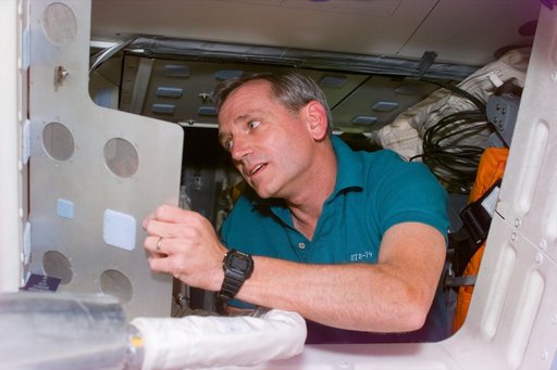 Astronaut Akers cleans-up on the middeck