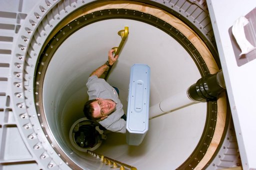 MS Wisoff moves stowage item through transfer tunnel