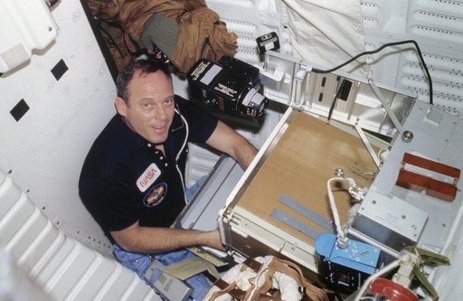 Commander Lousma works with EEVT experiment on aft middeck