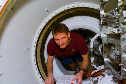 Mission Specialist Joe Tanner floats through the tunnel adapter