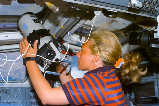 Davis holds Large Format camera pointed out the overhead flight deck windows