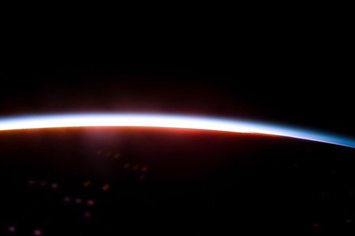 The Earth limb glows shortly after an orbital sunrise