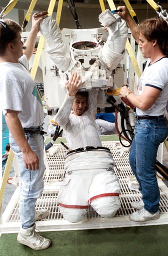 STS-38 Mission Specialist (MS) Robert C. Springer dons EMU in JSC's WETF