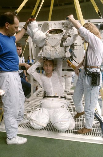 STS-38 Mission Specialist (MS) Carl J. Meade dons EMU in JSC's WETF Bldg 29