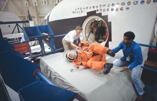 STS-38 Pilot Culbertson rolls through CCT side hatch during egress training