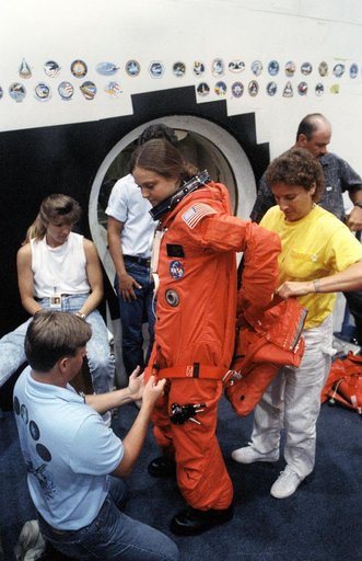 STS-40 MS Jernigan dons LES parachute pack prior to egress training at JSC