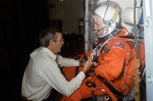 STS-41 MS Akers assisted by technician on SMS middeck at JSC