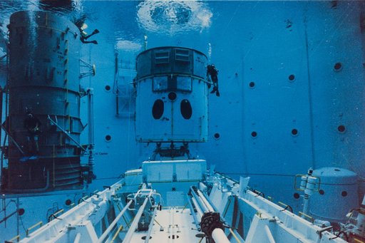 Safety divers prepare HST mockup in the Neutral Buoyancy Simulator at MSFC