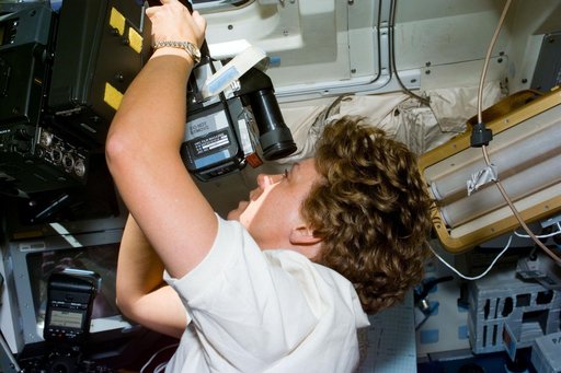 Collins takes photographs of the Earth using a 70mm Hasselblad camera