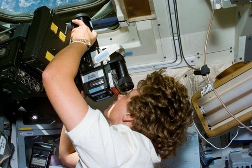 Collins takes photographs of the Earth using a 70mm Hasselblad camera