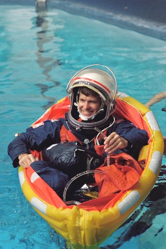 Astronaut Donald McMonagle checks drainage hose on his life raft in training