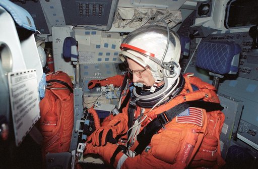 Astronaut Joseph Tanner checks gloves during during launch/entry training