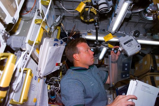 Lindsey sets up a camera to record and experiment in the Spacehab module
