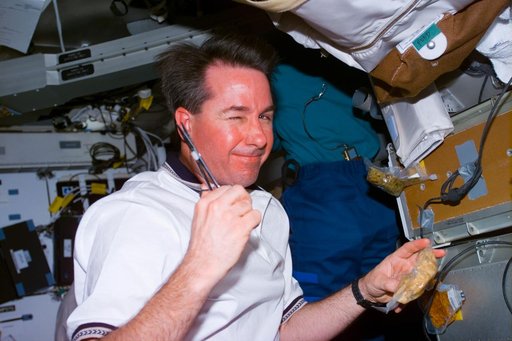 Robinson on middeck preparing a meal