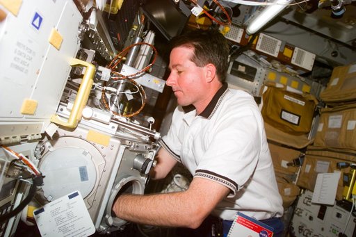 Robinson works with glovebox in the Spacehab module