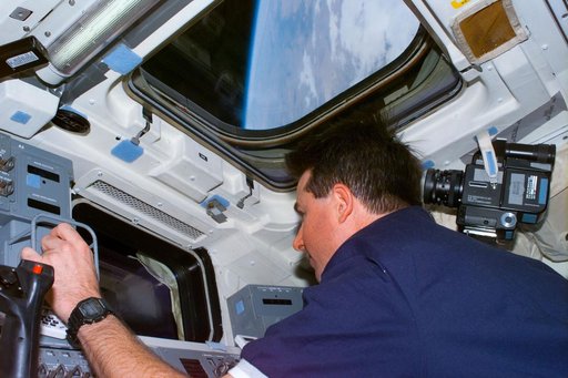 Robinson at RMS controls on aft flight deck during Spartan 201 retrieval