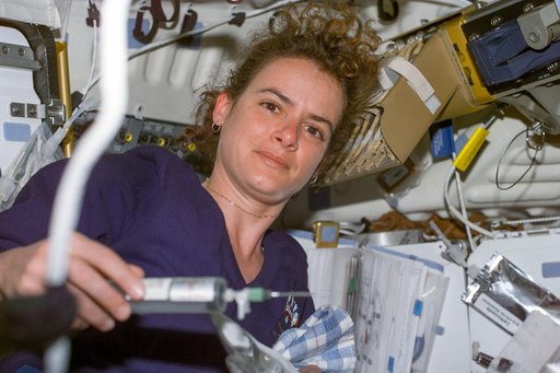 Julie Payette prepares to remove air bubbles from EVA drink packets