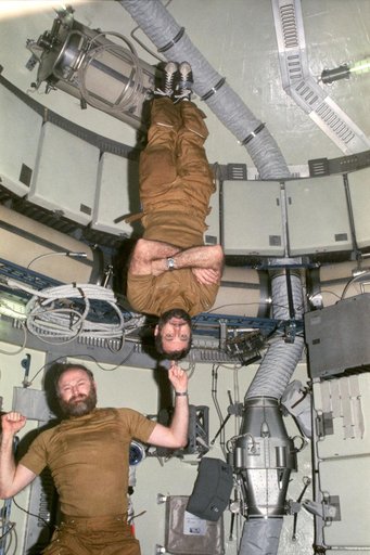 Astronauts Carr and Pogue demonstrate weight training in zero-gravity