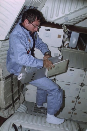 Commander Young removes CAP from FDF stowage locker on middeck