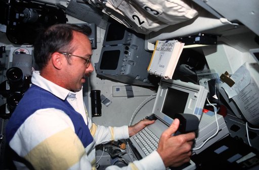 STS-43 MS Adamson conducts DTO 1208 using laptop on OV-104's flight deck
