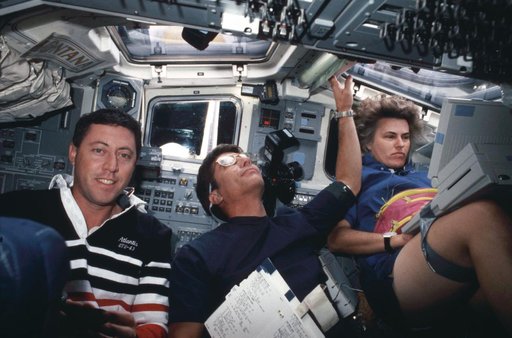 STS-43 crewmembers perform various tasks on OV-104's aft flight deck