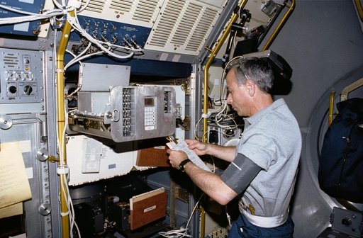 Crewmember working on the spacelab Generic Bioprocessing Apparatus, rack #10.