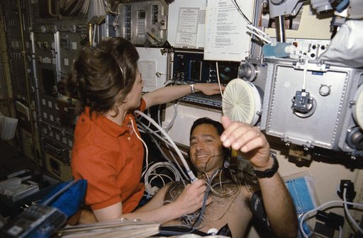 Crewmembers in the spacelab with the Lower Body Negative Pressure Study.