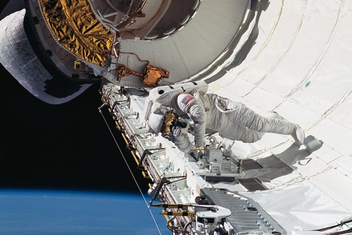 Astronaut James Newman evaluates tether devices in Discovery's payload bay