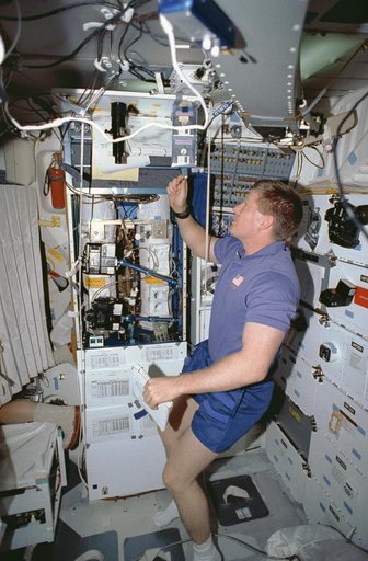 Crewmember in the middeck tending the CVTE and LBNP experiments.